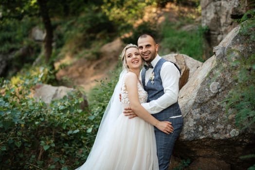 the groom and the bride are walking in the forest on a bright day