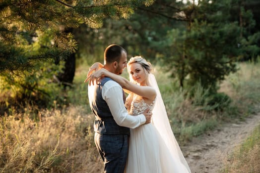 the groom and the bride are walking in the forest on a bright day