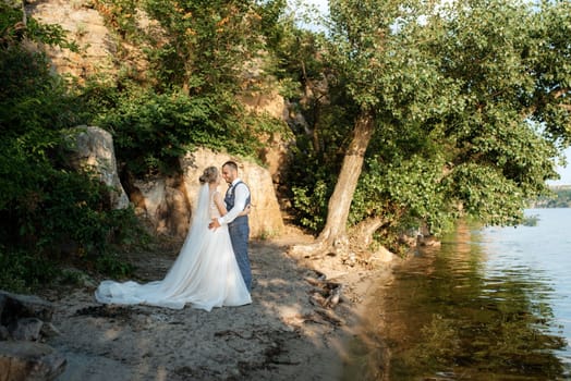 bride blonde girl and groom near the river at sunset light