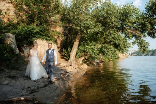 bride blonde girl and groom near the river at sunset light