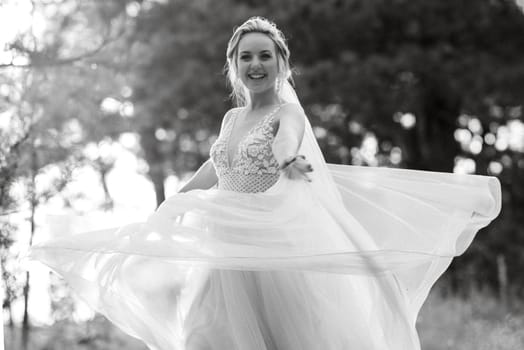 bride blonde girl with a bouquet in the forest in the sunset light