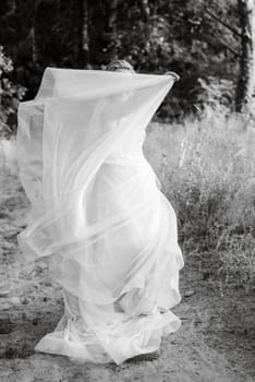 bride blonde girl with a bouquet in the forest in the sunset light