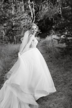 bride blonde girl with a bouquet in the forest in the sunset light