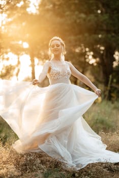 bride blonde girl with a bouquet in the forest in the sunset light