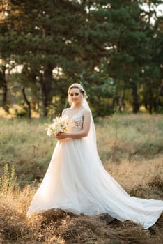 bride blonde girl with a bouquet in the forest in the sunset light