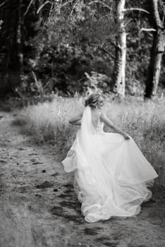 bride blonde girl with a bouquet in the forest in the sunset light