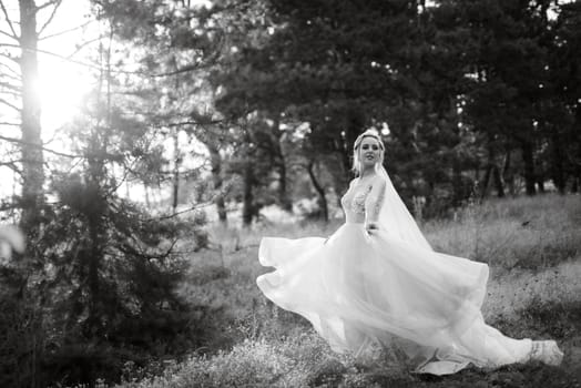 bride blonde girl with a bouquet in the forest in the sunset light