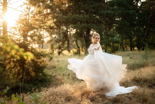 bride blonde girl with a bouquet in the forest in the sunset light