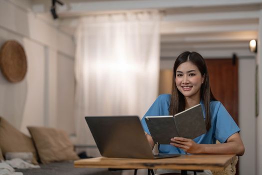 Beautiful business woman using a laptop computer. Portrait of asian...