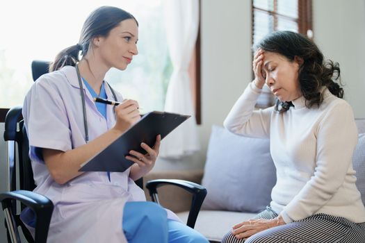 Portrait of a female doctor talking to an elderly patient showing headache