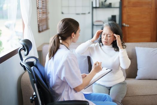 Portrait of a female doctor talking to an elderly patient showing headache