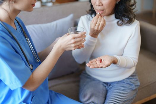 Portrait of a female doctor giving medicine to an elderly patient