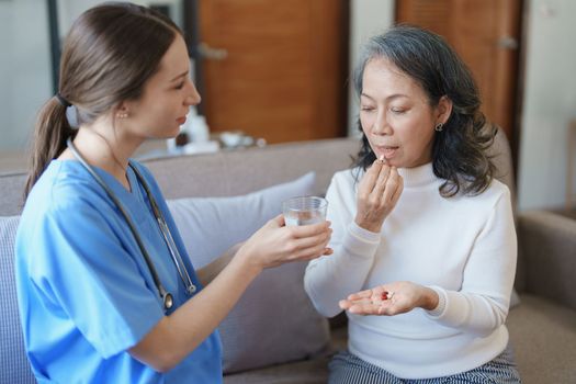 Portrait of a female doctor giving medicine to an elderly patient