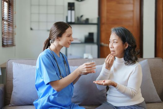 Portrait of a female doctor giving medicine to an elderly patient