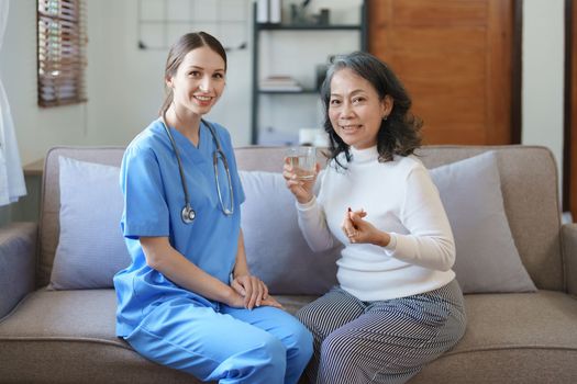 Portrait of a female doctor giving medicine to an elderly patient