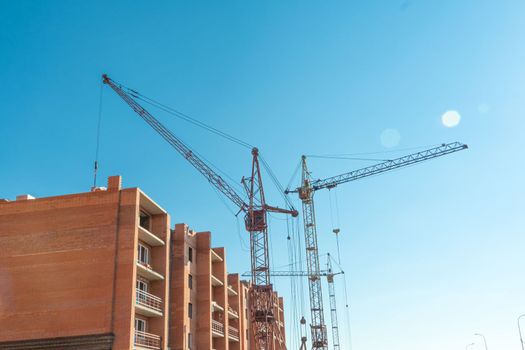 Construction site with a crane.Long-term construction.A new building under construction,bottom-up view.Unfinished skyscraper,frozen construction.Unfinished construction of a multi-storey residential