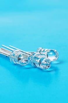 Three white LEDs diodes on a blue background close up