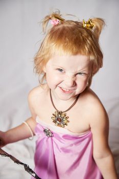 Portrait of cute kid girl posing in pink beautiful dress on white background. Young female model looking as magic princess from fairy taly