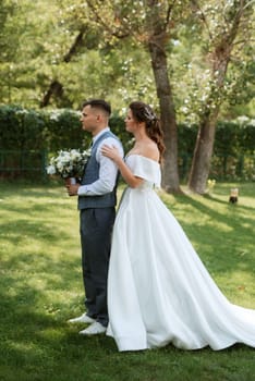 the first meeting of the bride and groom in wedding outfits in the park