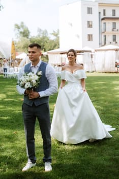 the first meeting of the bride and groom in wedding outfits in the park