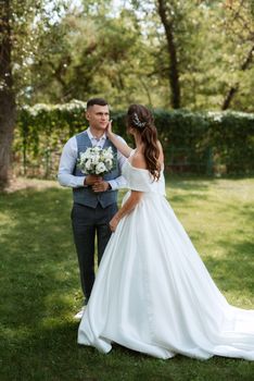 the first meeting of the bride and groom in wedding outfits in the park