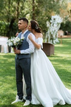 the first meeting of the bride and groom in wedding outfits in the park