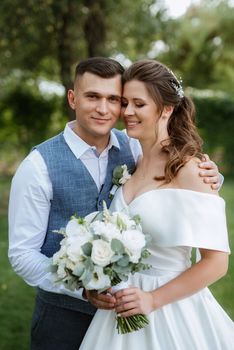 the first meeting of the bride and groom in wedding outfits in the park