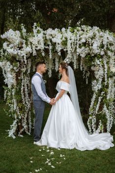 wedding ceremony of the newlyweds on the glade near the restaurant