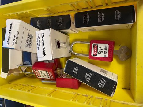 Lock out tag out locks locks in a yellow tote. High quality photo