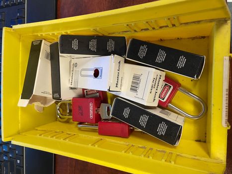 Lock out tag out locks locks in a yellow tote. High quality photo