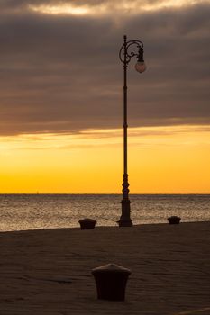 Street lamp at sunset next to the Trieste sea