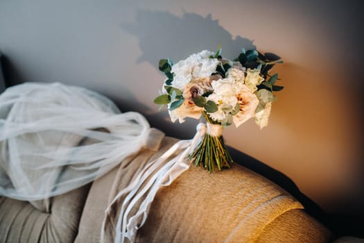 wedding bouquet with roses on a chair and boutonniere.The decor at the wedding.