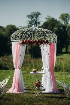 Wedding ceremony on the street on the green lawn.Decor with fresh flowers arches for the ceremony.