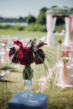 Wedding ceremony on the street on the green lawn.Decor with fresh flowers arches for the ceremony.