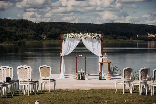 Wedding ceremony on the street on the green lawn.Decor with fresh flowers arches for the ceremony.