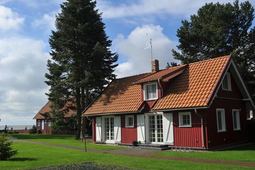 old old wooden house, red, in the European country of Lithuania, in the spa town of Nida, on the Curonian Spit.