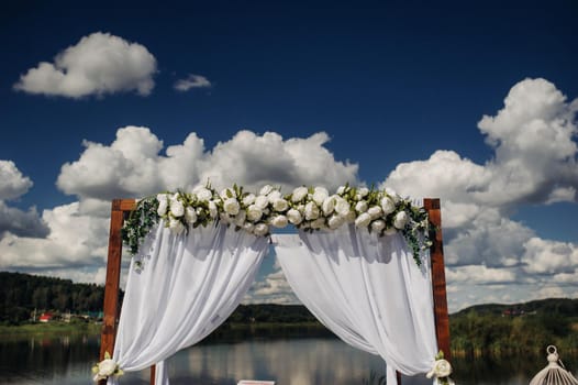 Wedding ceremony on the street on the green lawn.Decor with fresh flowers arches for the ceremony.