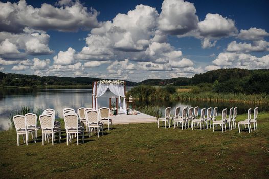 Wedding ceremony on the street on the green lawn.Decor with fresh flowers arches for the ceremony.