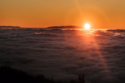 a spectacular sunset above the clouds in the national Park of the volcano Teide on Tenerife. Excellent sunset in the Canary Islands.