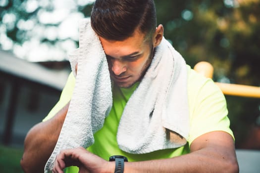 Fit man checking smart watch wearable technology sport smartwatch on workout outside. Man wearing smart watch during his training, measuring his activity. High quality photo