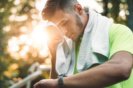 Fit man checking smart watch wearable technology sport smartwatch on workout outside. Man wearing smart watch during his training, measuring his activity. High quality photo