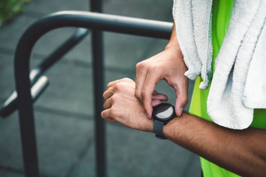 Fit man checking smart watch wearable technology sport smartwatch on workout outside. Man wearing smart watch during his training, measuring his activity. High quality photo