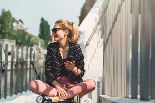 Beautiful caucasian woman living in the city. Woman spending her day in the city, sun is shining, weather is nice. Young millennial person living in the city, doing his daily errands.