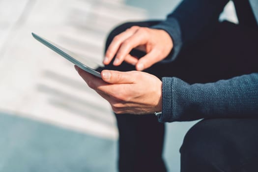 Beautiful caucasian man living in the city. Man spending his day in the city, sun is shining, weather is nice. Young millennial person living in the city, doing his daily errands always using his digital devices, tablet or phone.