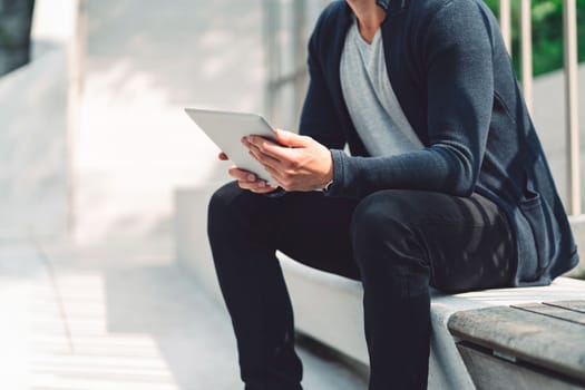 Beautiful caucasian man living in the city. Man spending his day in the city, sun is shining, weather is nice. Young millennial person living in the city, doing his daily errands always using his digital devices, tablet or phone.