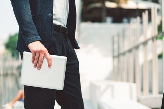 Beautiful caucasian man living in the city. Man spending his day in the city, sun is shining, weather is nice. Young millennial person living in the city, doing his daily errands always using his digital devices, tablet or phone.