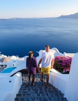 A couple walking at the village of Oia Santorini Greece, men and women visit the whitewashed Greek village of Oia during summer vacation