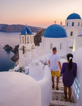 A couple walking at the village of Oia Santorini Greece, men and women visit the whitewashed Greek village of Oia during summer vacation