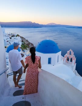 A couple walking at the village of Oia Santorini Greece, men and women visit the whitewashed Greek village of Oia during summer vacation