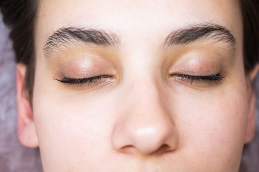 Woman lying on the couch after eyelash lamination procedure